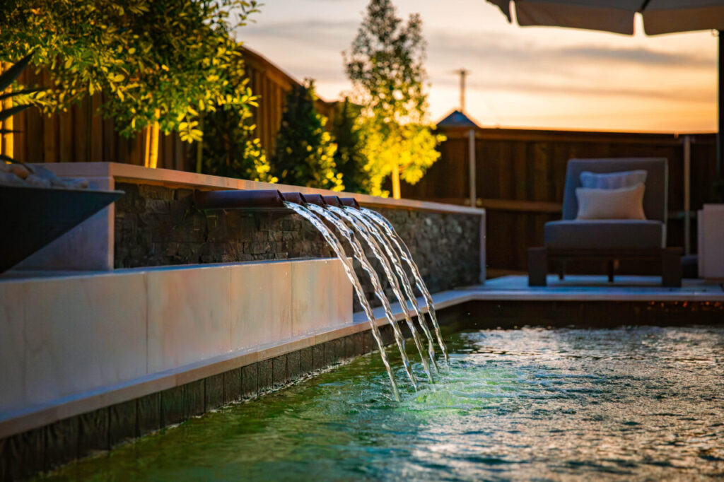 Custom pool with modern spillway water features in North Texas